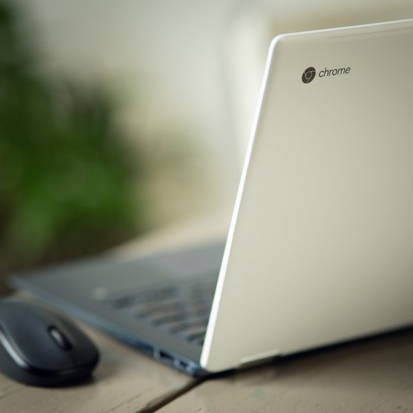 An open Chromebook with a mouse next to it.